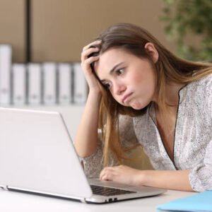 image of unhappy woman staring at a computer screen